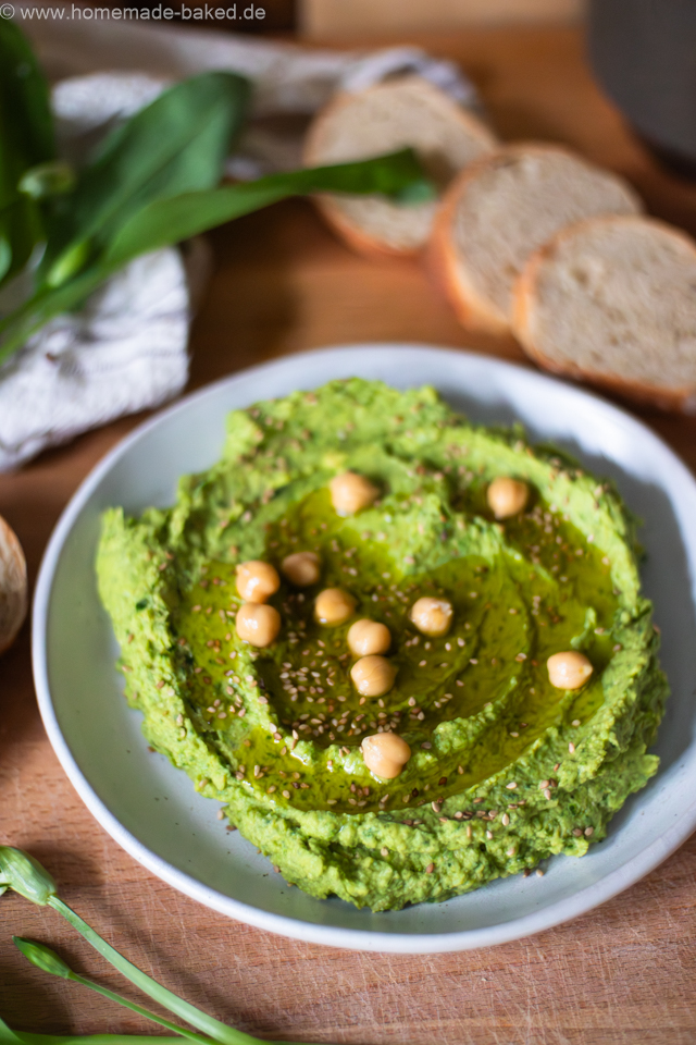 Cremiger Bärlauchhummus in einer Schale, garniert mit Olivenöl und frischem Bärlauch – frischer Frühlingsdip aus Kichererbsen