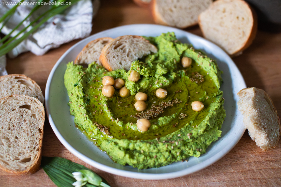 Cremiger Bärlauchhummus in einer Schale, garniert mit Olivenöl und frischem Bärlauch – frischer Frühlingsdip aus Kichererbsen