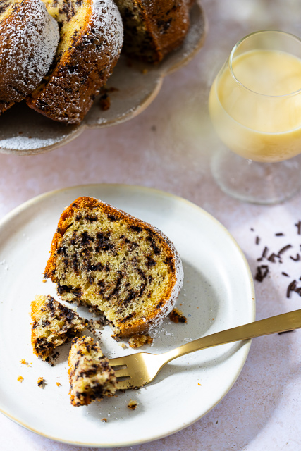 Ein Stück saftiger Eierlikör-Gugelhupf mit Schokostreuseln auf einem Dessertteller
