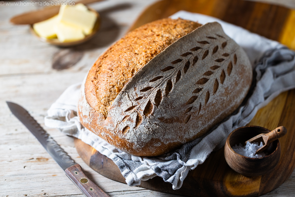weizen emmer sauerteigbrot mit schönem Ährenmuster eingeschnitten auf einem Brett