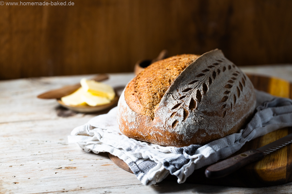 weizen emmer sauerteigbrot mit schönem Ährenmuster eingeschnitten auf einem Brett