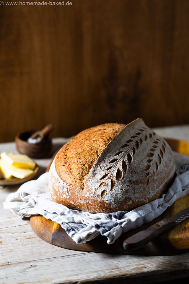 weizen emmer sauerteigbrot mit schönem Ährenmuster eingeschnitten auf einem Brett