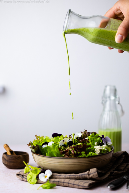 Cremiges Bärlauch-Buttermilch-Dressing wird über frischen Salat gegossen.