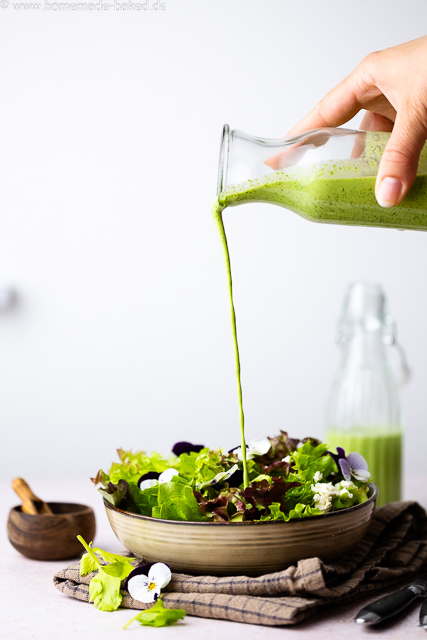 Cremiges Bärlauch-Buttermilch-Dressing wird über frischen Salat gegossen.