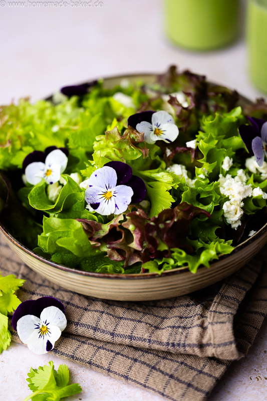 Frischer Salat mit Bärlauch-Buttermilch-Dressing, Feta und essbaren Blumen