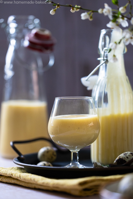 Selbstgemachter Eierlikör mit ganzen Eiern aus dem Thermomix in zwei Flaschen und einem Glas. Das Glas und eine Flasche auf einem Tablett