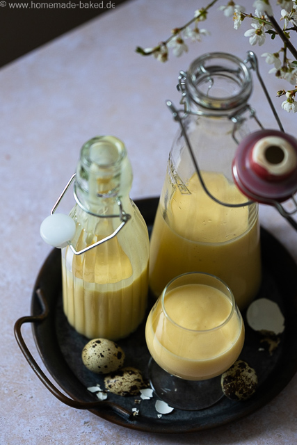 Selbstgemachter Eierlikör mit ganzen Eiern aus dem Thermomix in zwei Flaschen und einem Glas auf einem Tablett