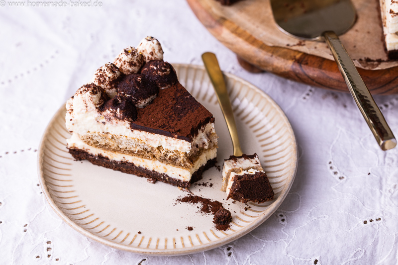 Stück No Bake Tiramisu Käsekuchen mit Kaffee, Mascarpone und Kakao auf einem Teller, mit einer Kuchengabel daneben