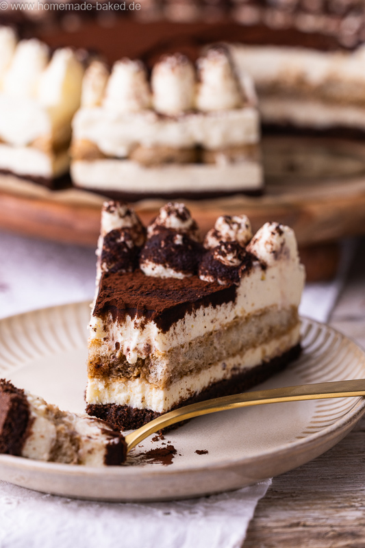Stück No Bake Tiramisu Käsekuchen mit Kaffee, Mascarpone und Kakao auf einem Teller, mit einer Kuchengabel daneben
