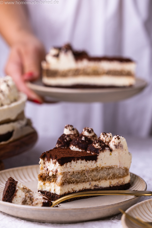 Stück No Bake Tiramisu Käsekuchen mit Kaffee, Mascarpone und Kakao auf einem Teller, mit einer Kuchengabel daneben