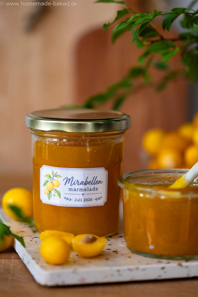 Ein geschlossenes Glas Mirabellenmarmelade mit Vanille, davor ein frisch geöffnetes Marmeladenglas