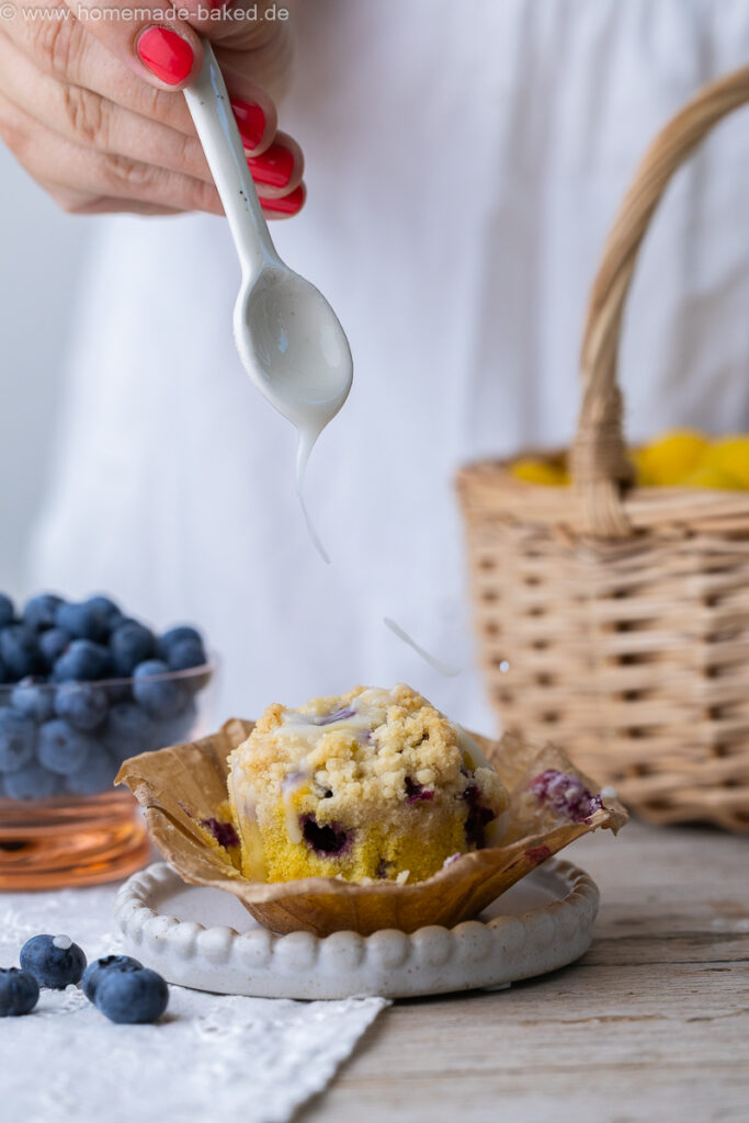 thermomix streuselmuffins mit heidelbeeren werden gerade mit zuckerguss begossen
