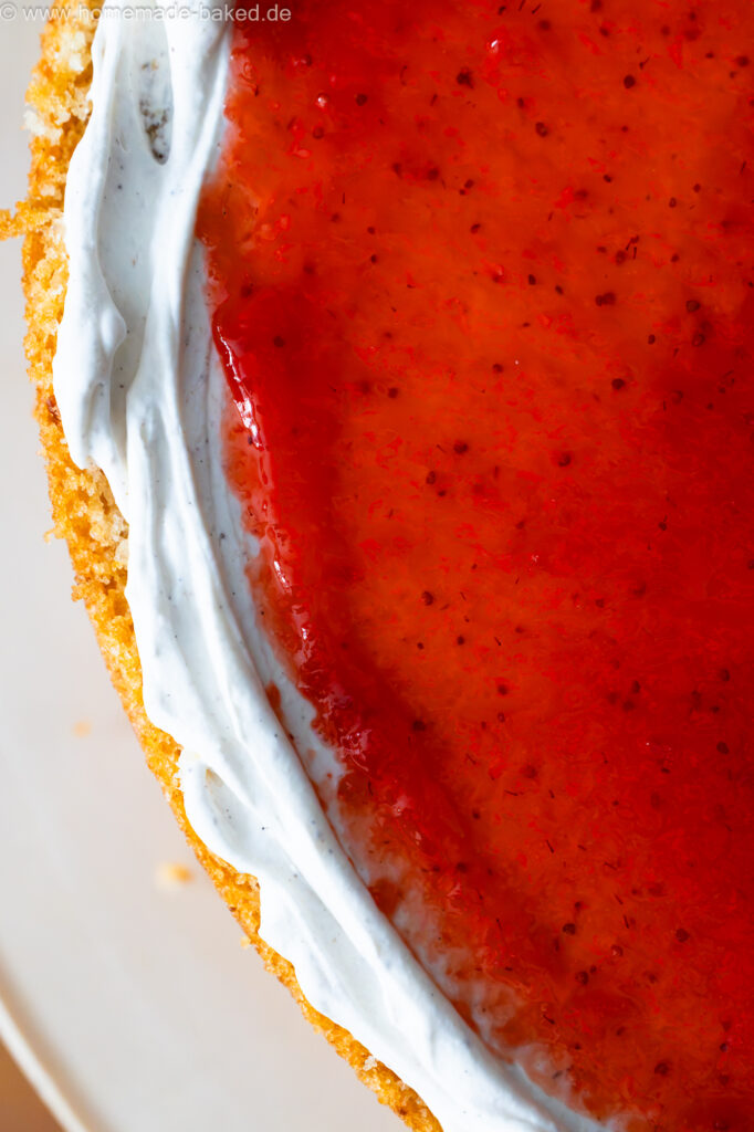 vegane Torte beim Füllen: Vanilleböden, Sahne-Frischkäsecreme und frische Erdbeermarmelade