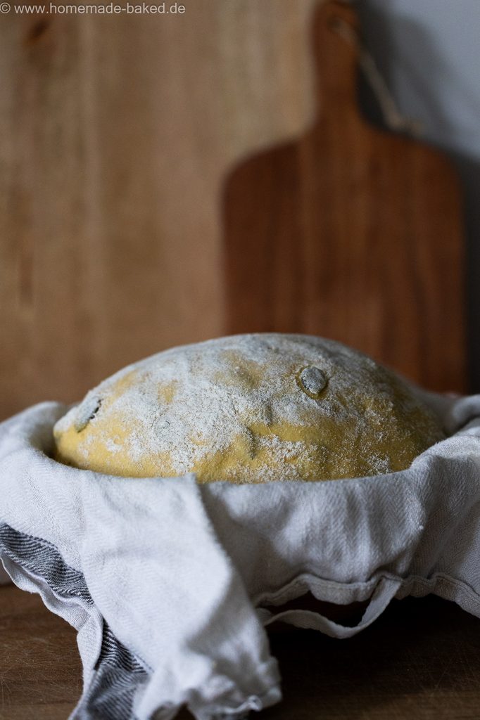 Kürbis-Sauerteigbrot vor dem Backen im Gärkörbchen mit Leinentuch