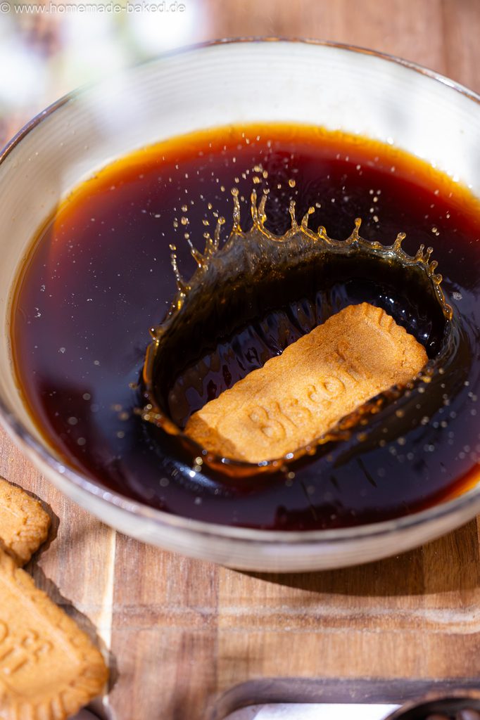 Lotus Biscoff Keks, der in eine Schüssel mit Kaffee fällt, mit Kaffeesplash